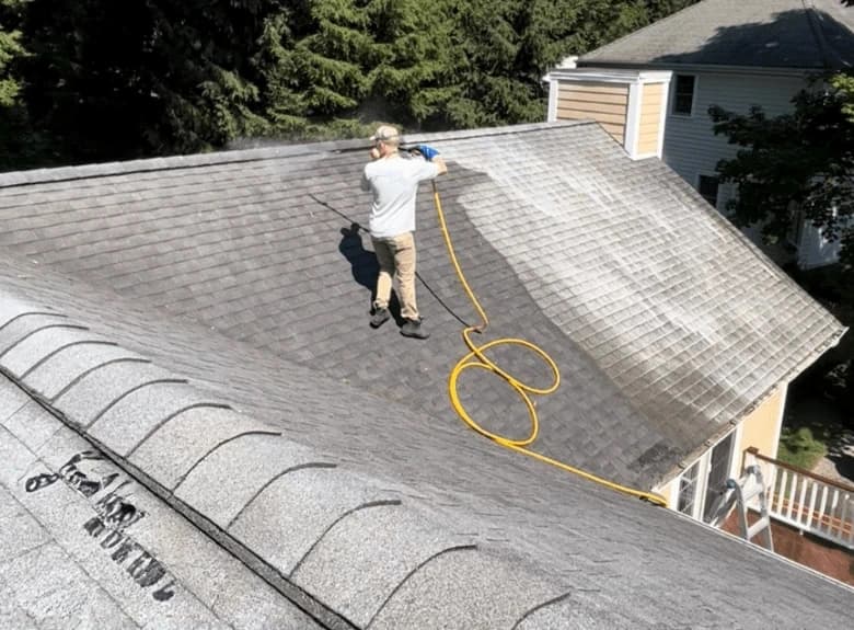 Brecksville Power Washing professional cleaning and inspecting gutters on Brecksville home